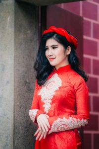 Traditional Vietnamese Ao Dai in red, worn by a beautiful Vietnamese woman